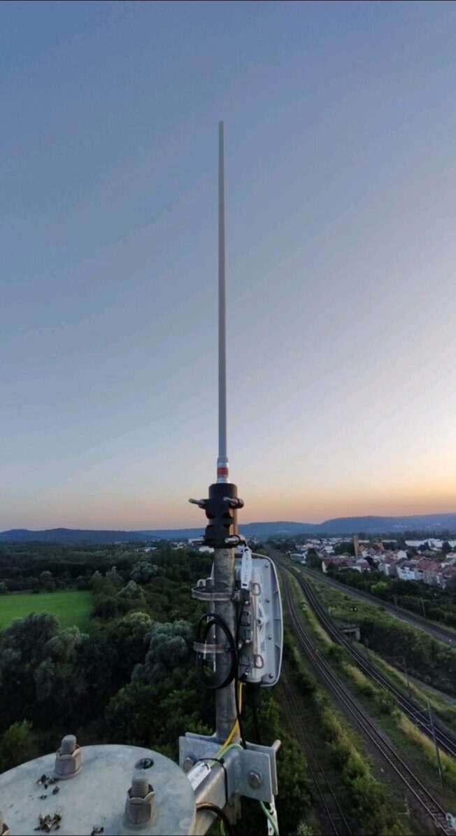 LoRaWAN gateway mast at sunset overlooking rail corridor