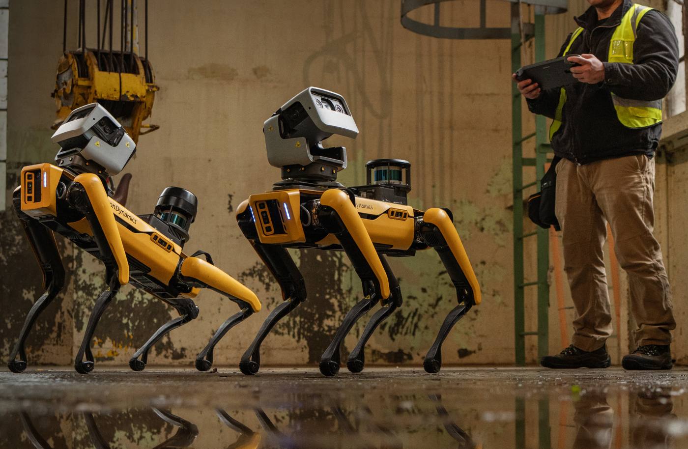 Boston Dynamics Spot robots with an operator in an industrial facility
